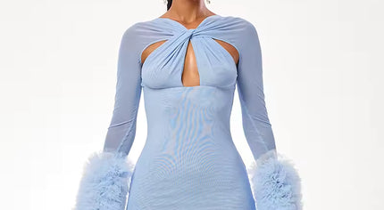 Woman wearing a light blue dress with feathered sleeves on a white background