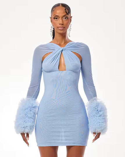 Woman wearing a light blue dress with feathered sleeves on a white background